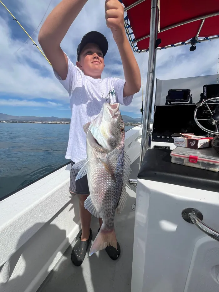 Boy showing a dentex caught during a fishing trip in Marbella