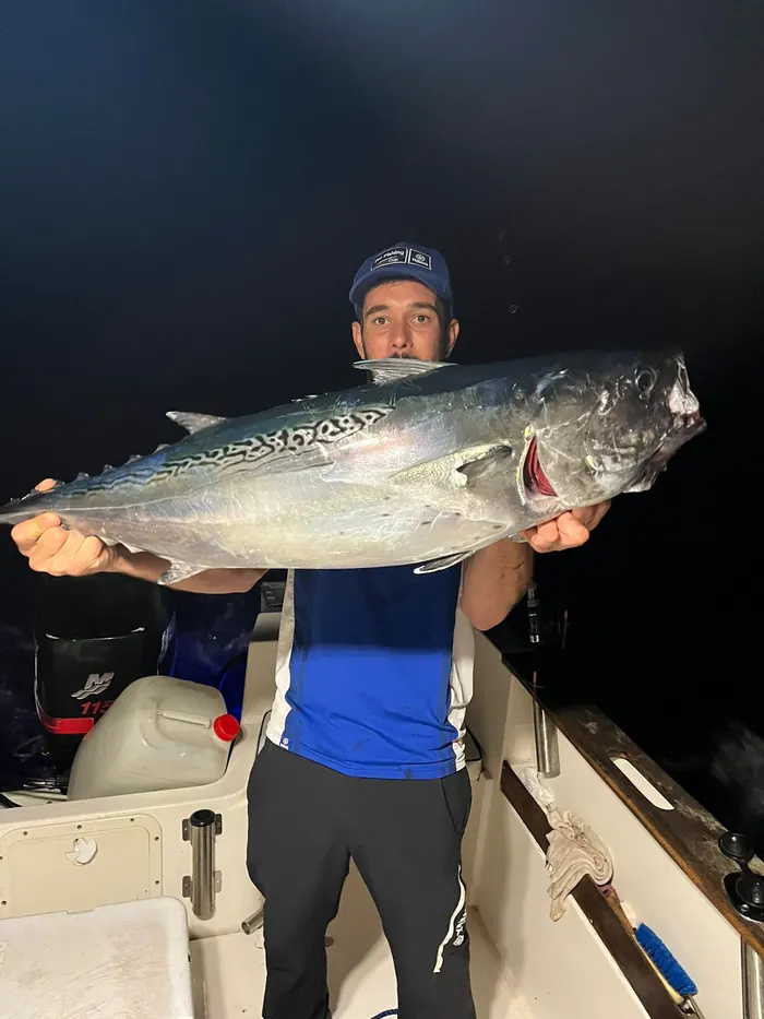 Patrón de Fishing Trips Marbella sujetando un atún capturado a bordo durante una salida nocturna de pesca del atún en Marbella