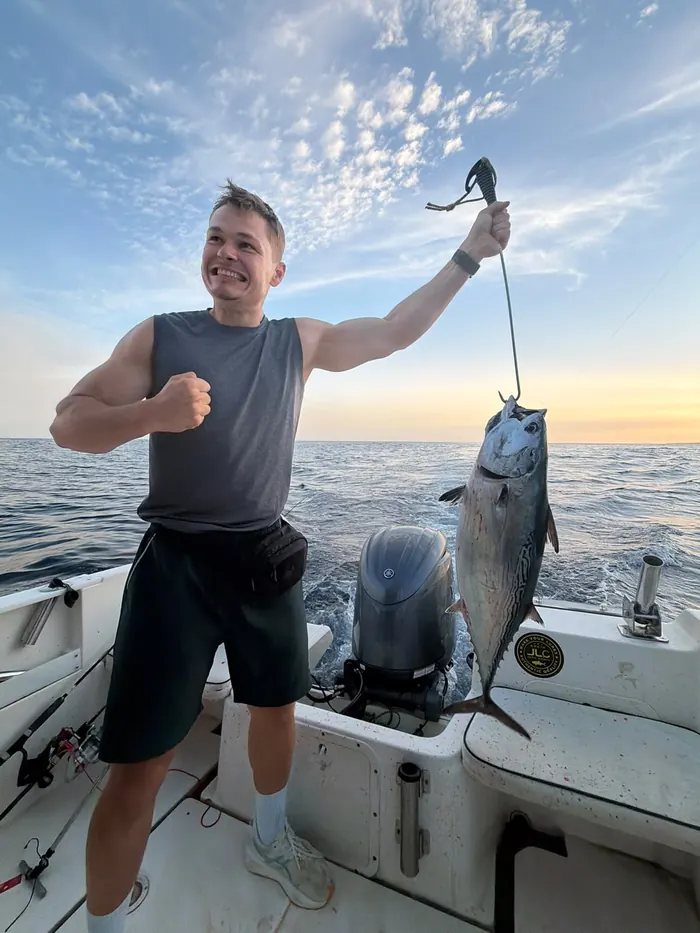 Smiling angler showing a bonito caught at sunset during a fishing trip in Marbella