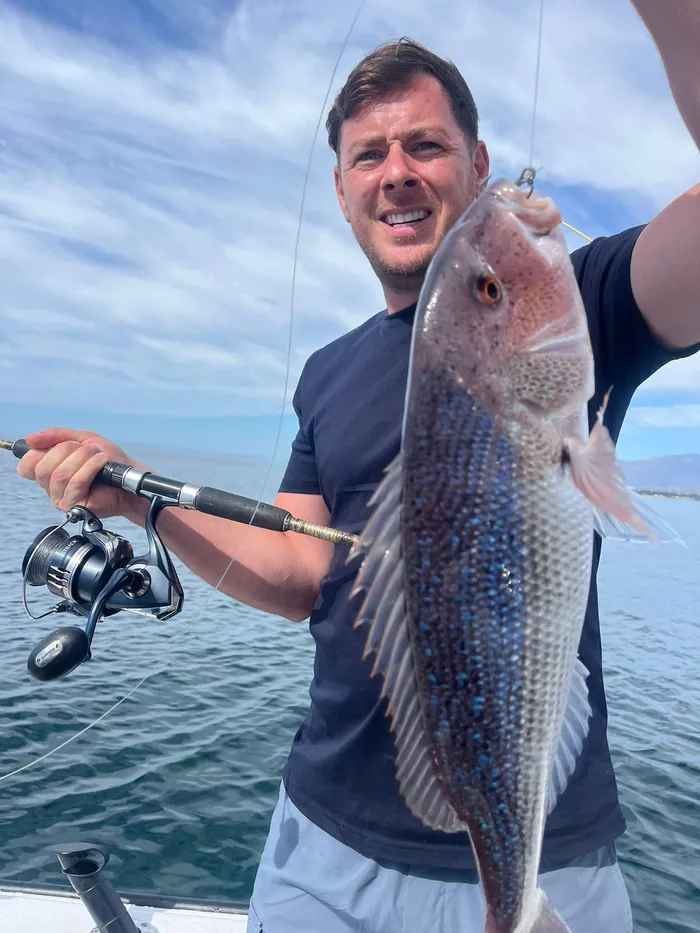 Angler holding a red porgy caught while rod fishing in Marbella